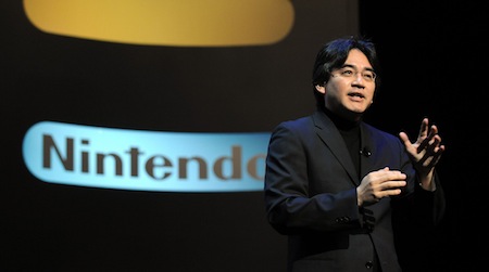 Nintendo-president-Satoru-Iwata-in-black-suit-on-stage-giving-a-presentation